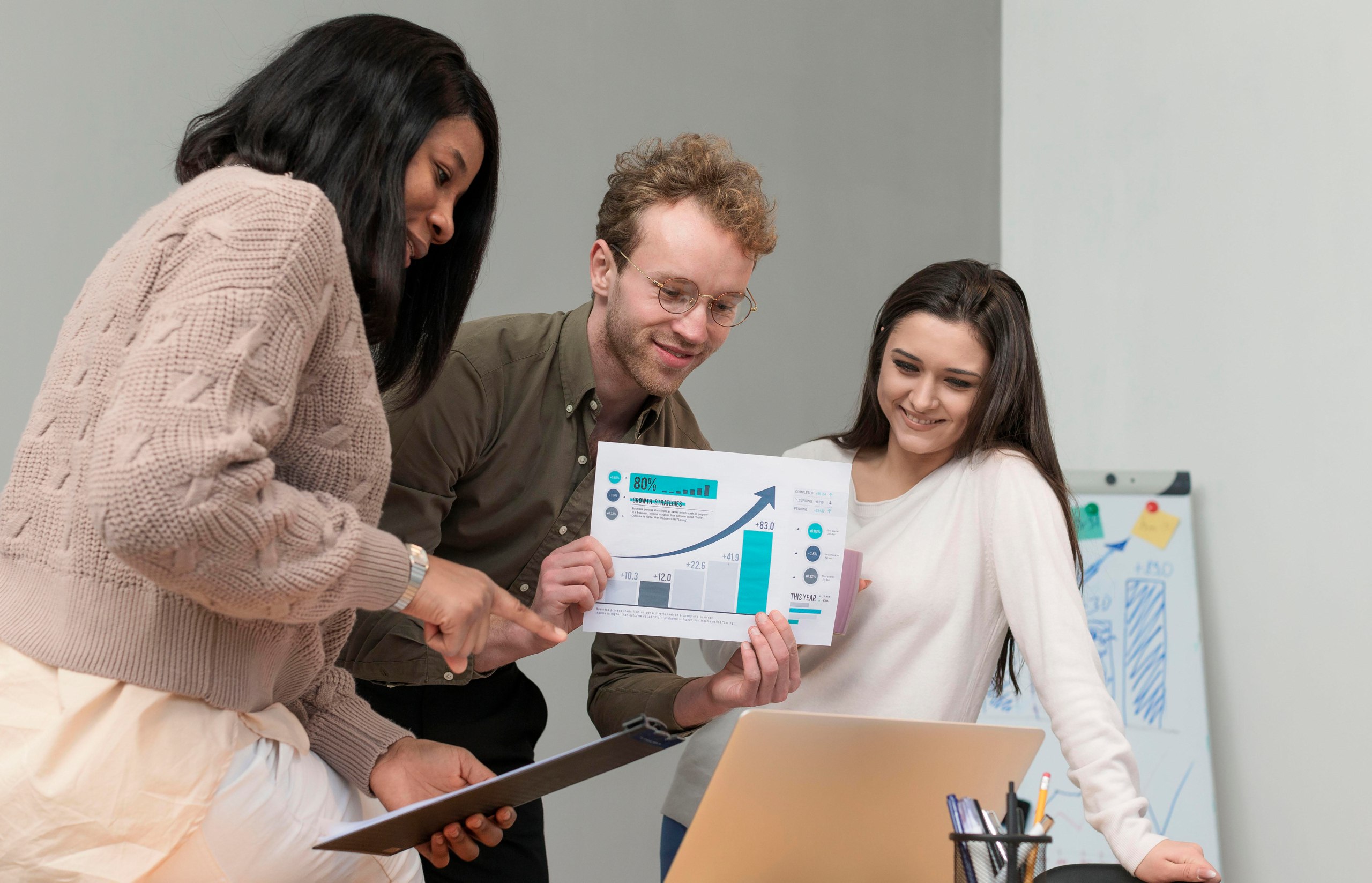 Three diverse colleagues discussing a business graph - MaherTech Inc