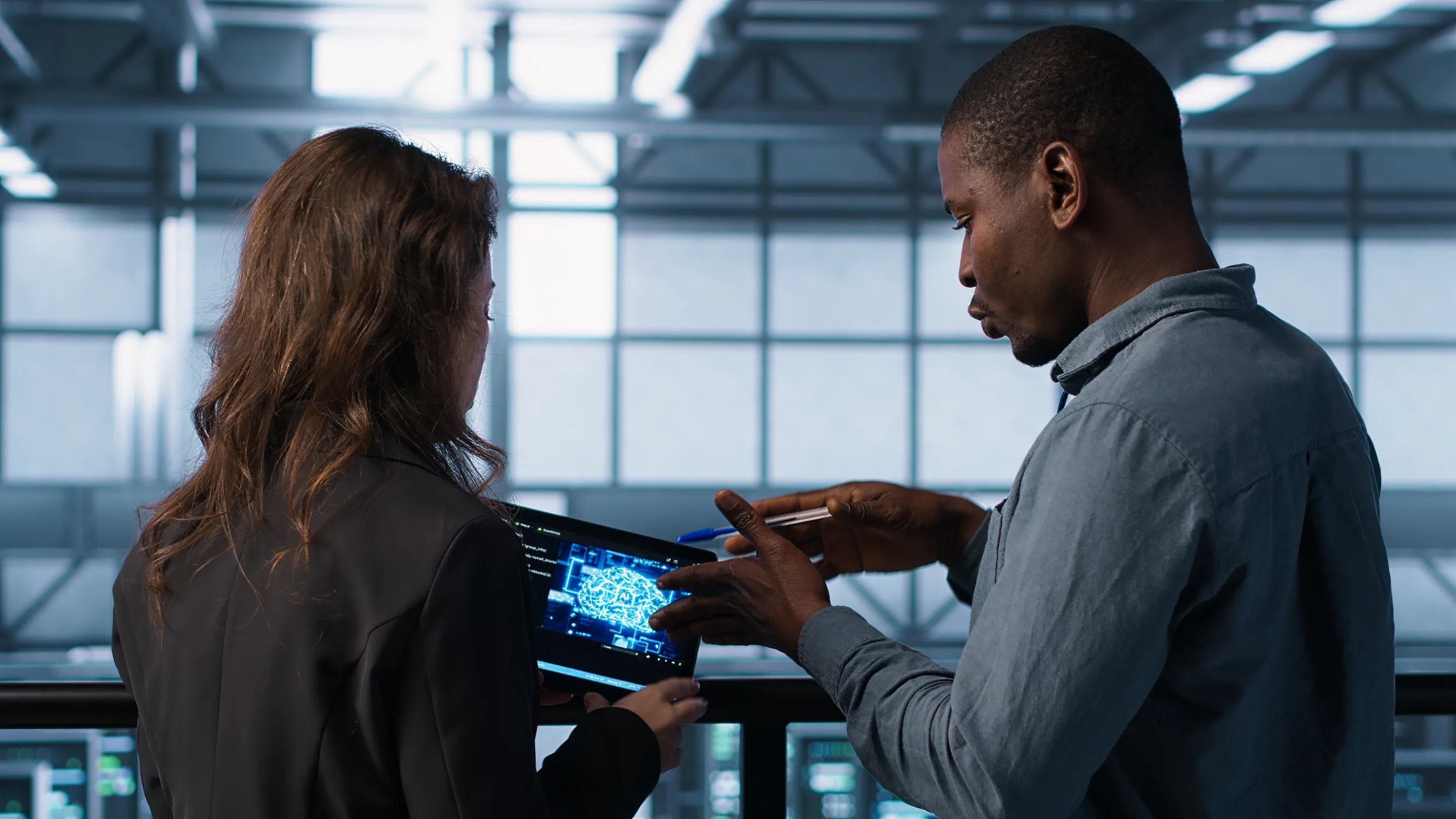 Two people discussing data on a tablet in a server room - MaherTech Inc